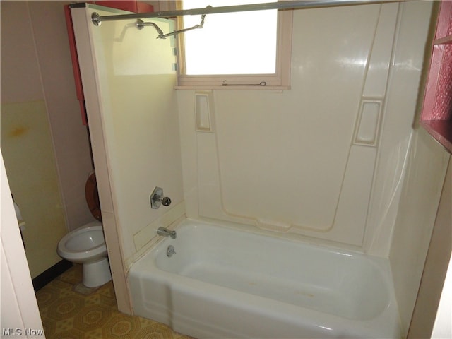 bathroom with tile flooring, toilet, and bathtub / shower combination