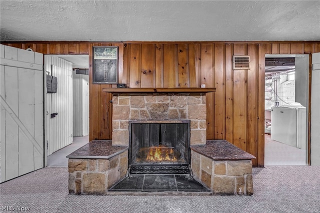 interior details featuring carpet, a textured ceiling, wooden walls, and a fireplace