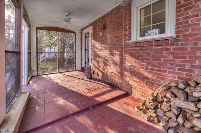 unfurnished sunroom featuring ceiling fan