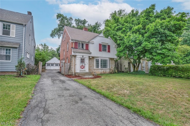 view of front of home featuring an outbuilding, a garage, and a front lawn