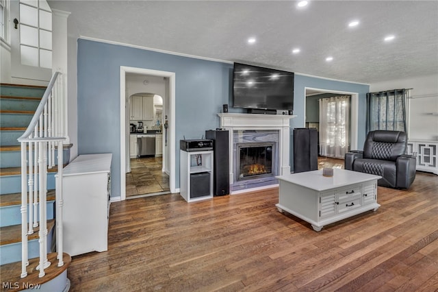 living room with a premium fireplace, crown molding, and dark hardwood / wood-style flooring