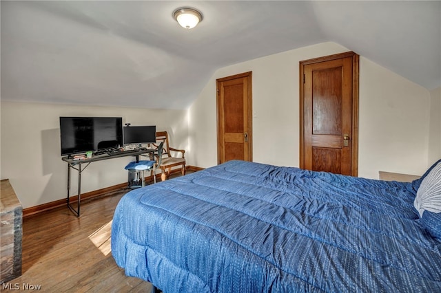 bedroom featuring hardwood / wood-style flooring and lofted ceiling