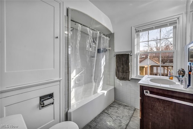 full bathroom featuring tile walls, vanity, toilet, tile patterned floors, and shower / bath combo with shower curtain