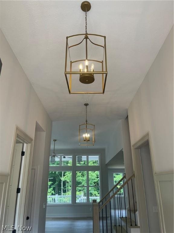 stairs featuring an inviting chandelier and hardwood / wood-style flooring