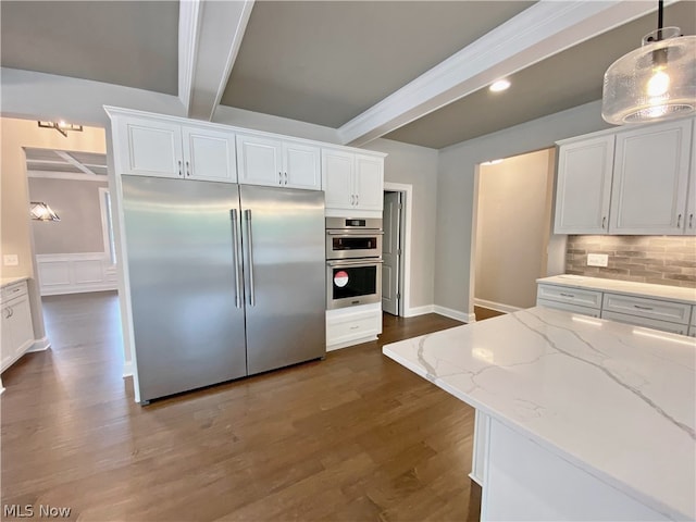 kitchen with white cabinets, appliances with stainless steel finishes, hanging light fixtures, and beamed ceiling