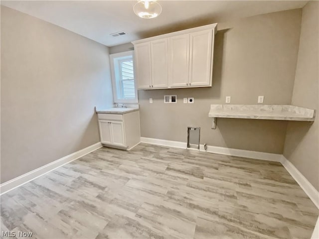 laundry room with cabinets, hookup for a gas dryer, washer hookup, light wood-type flooring, and hookup for an electric dryer