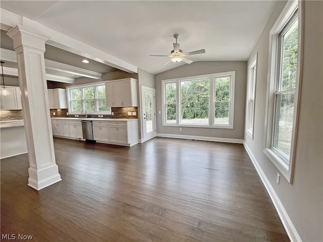 unfurnished living room featuring ornate columns, ceiling fan, dark wood-type flooring, sink, and vaulted ceiling with beams