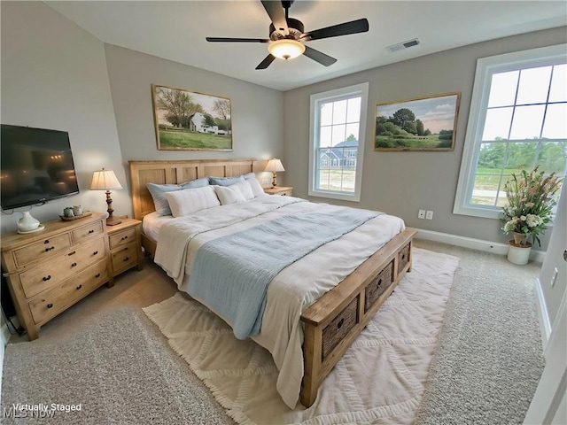 carpeted bedroom with multiple windows and ceiling fan