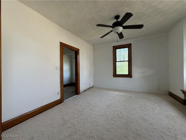 empty room featuring ceiling fan, light carpet, and a textured ceiling