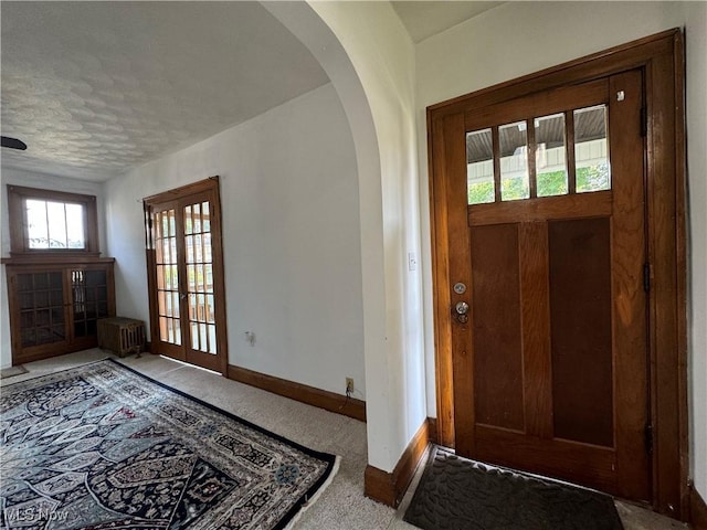 carpeted entryway featuring radiator and a textured ceiling