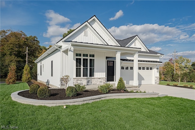 view of front of home with covered porch, a front yard, and a garage