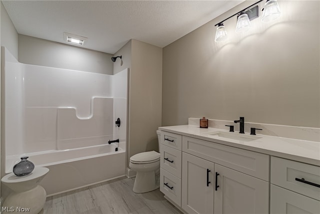 full bathroom featuring hardwood / wood-style floors, washtub / shower combination, a textured ceiling, toilet, and vanity