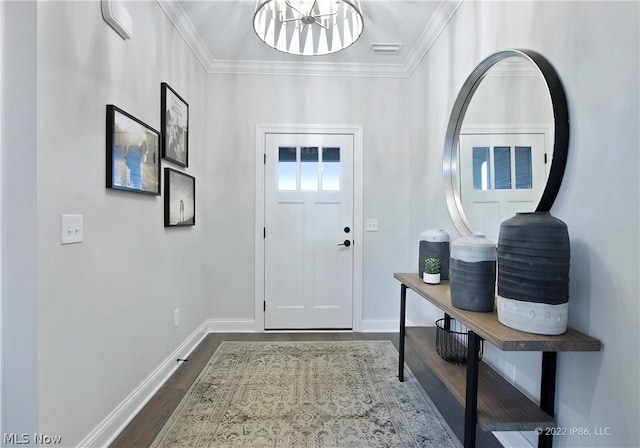 foyer entrance with crown molding, dark hardwood / wood-style flooring, and a chandelier