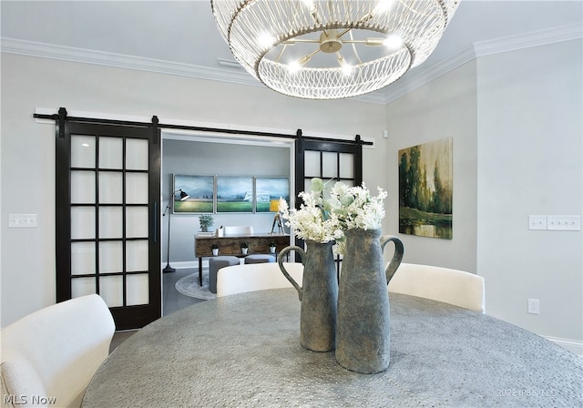 dining area featuring a chandelier, ornamental molding, and a barn door