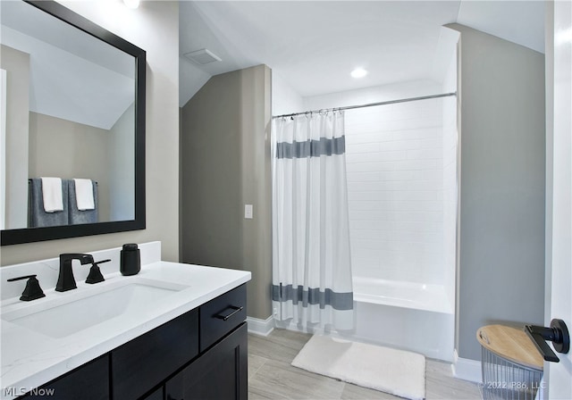 bathroom featuring hardwood / wood-style floors, vanity, and shower / tub combo with curtain