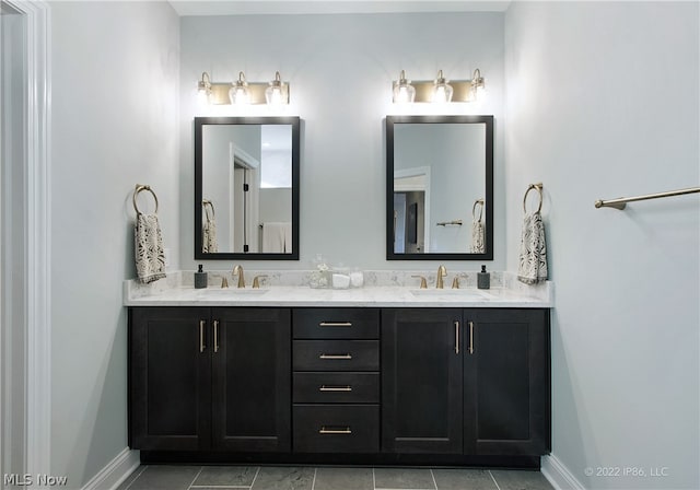 bathroom with tile patterned floors and dual bowl vanity