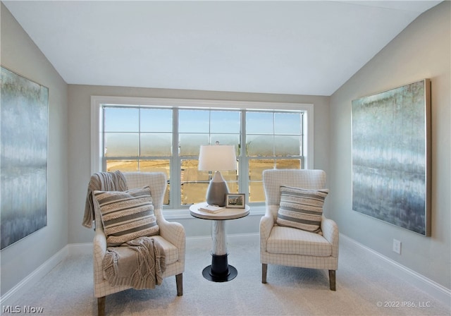 living area featuring carpet floors, lofted ceiling, and a wealth of natural light