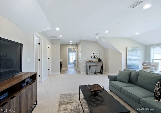 living room featuring light carpet and vaulted ceiling