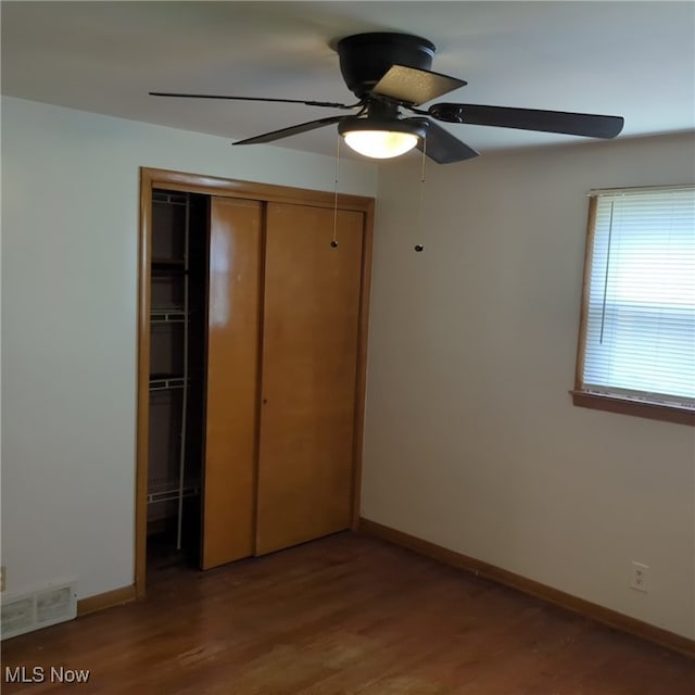 unfurnished bedroom with wood-type flooring, a closet, and ceiling fan