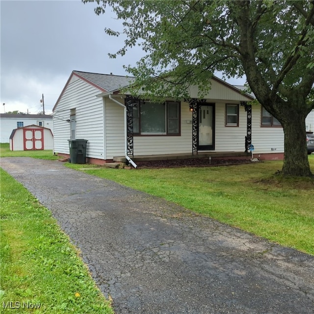 view of front of house featuring a shed and a front lawn