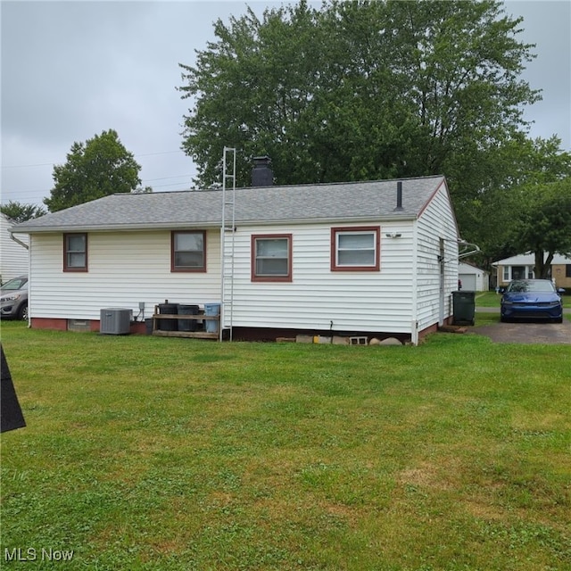 back of house with a yard and central air condition unit