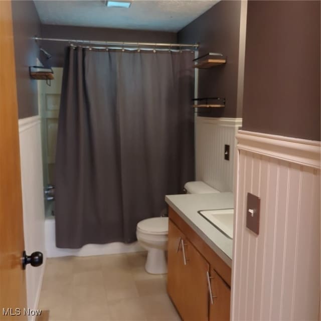 full bathroom featuring vanity, shower / tub combo with curtain, toilet, and tile patterned floors