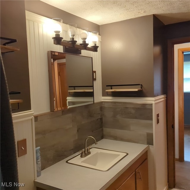 bathroom featuring vanity, decorative backsplash, and a textured ceiling