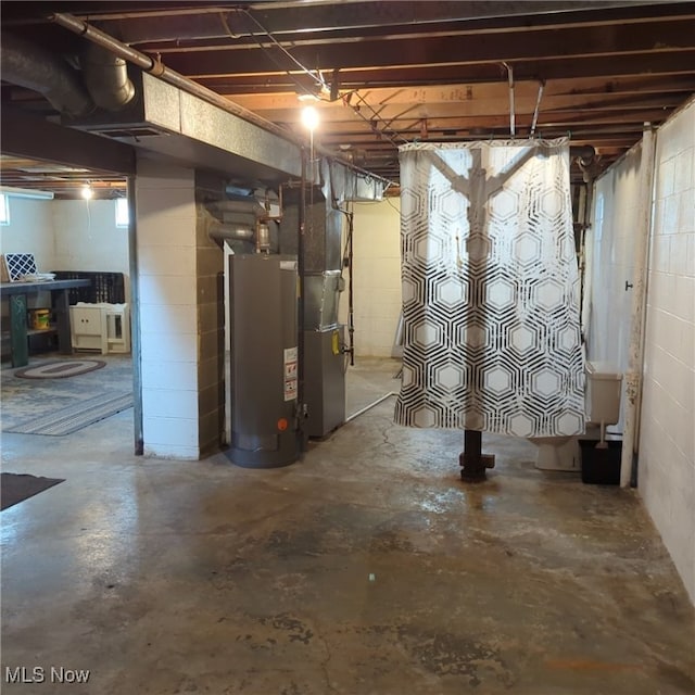 basement featuring gas water heater and heating unit