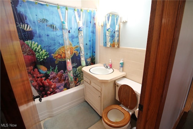 full bathroom with shower / tub combo with curtain, vanity, tasteful backsplash, tile walls, and toilet