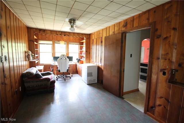 sitting room with tile patterned flooring and wooden walls