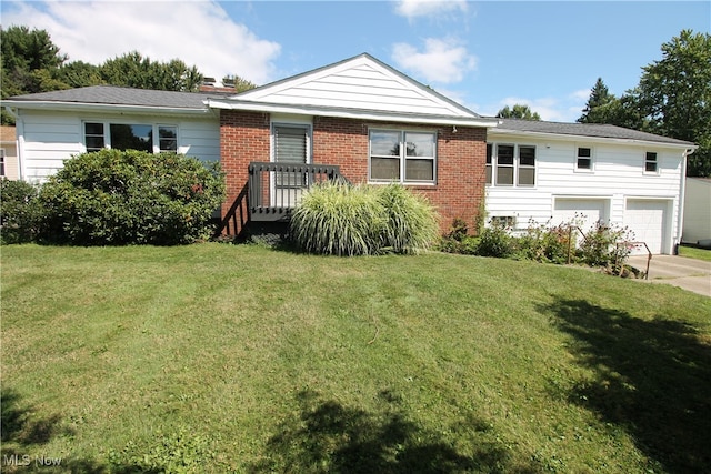 view of front facade featuring a front lawn, a wooden deck, and a garage