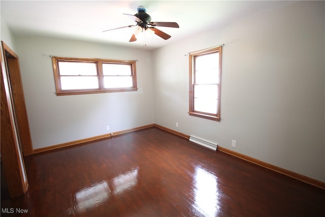 unfurnished bedroom with ceiling fan, hardwood / wood-style flooring, baseboard heating, and multiple windows