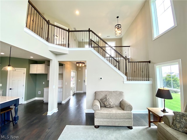 living room with a towering ceiling and dark hardwood / wood-style floors