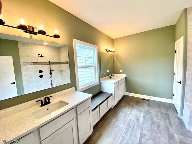 bathroom with hardwood / wood-style flooring, vanity, and walk in shower