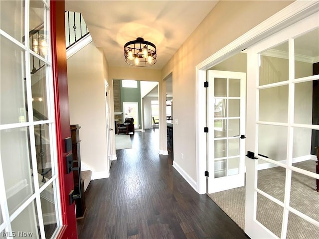 hall featuring dark wood-style floors, french doors, baseboards, and an inviting chandelier