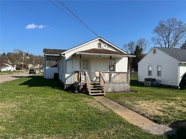 back of property with central AC unit and a yard