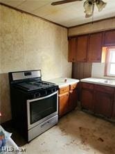 kitchen with stainless steel gas range, light countertops, and ceiling fan