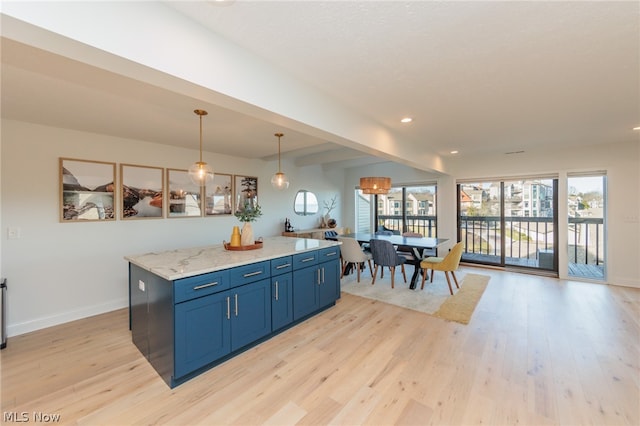 kitchen featuring pendant lighting, a healthy amount of sunlight, and light hardwood / wood-style flooring