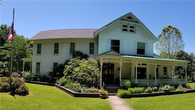 back of property featuring a porch and a yard