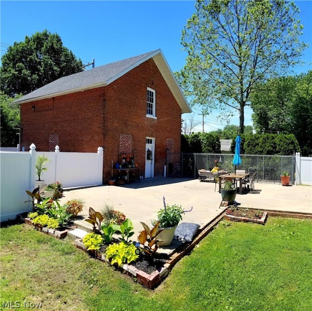 view of side of property with a lawn and a patio