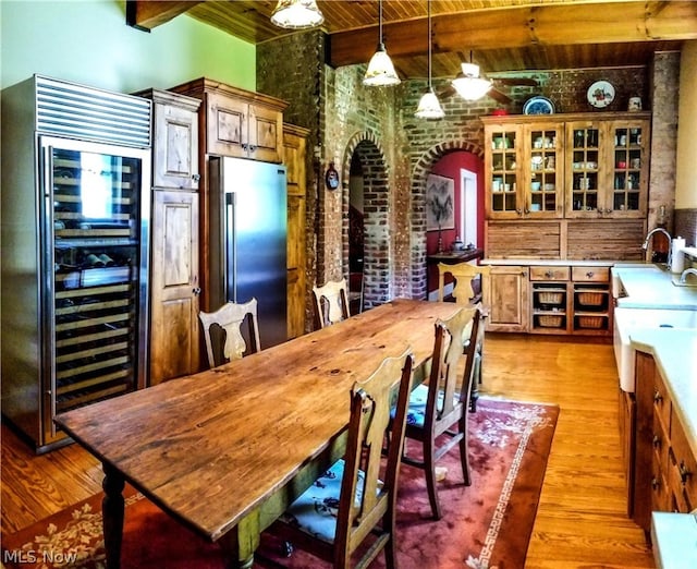 dining area with wood ceiling, light hardwood / wood-style floors, and beam ceiling