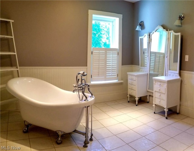 bathroom with a bathing tub, vanity, a wealth of natural light, and tile floors