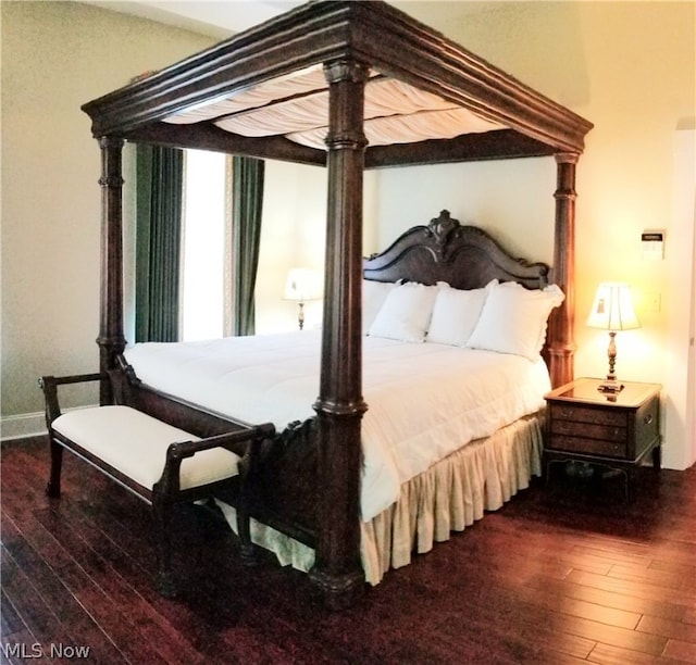 bedroom with dark wood-type flooring