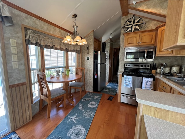 kitchen featuring an inviting chandelier, premium range hood, stainless steel appliances, and wood-type flooring