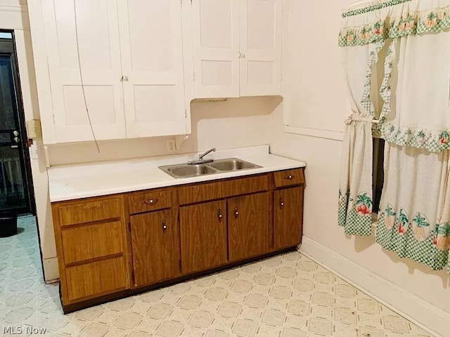 kitchen featuring sink and light tile flooring