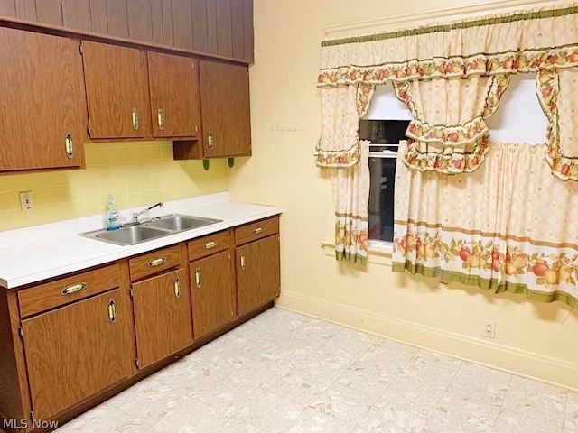 kitchen featuring backsplash, sink, and light tile flooring