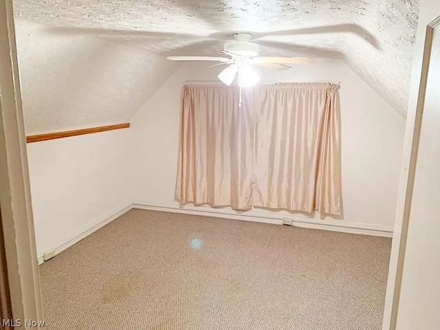 additional living space with light colored carpet, ceiling fan, a textured ceiling, and lofted ceiling