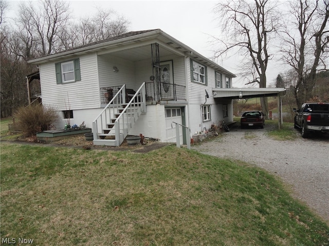 view of front of home with a front yard and a carport