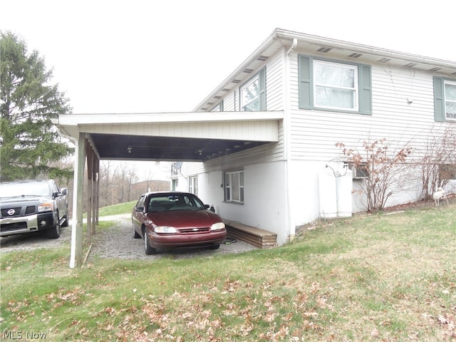 view of side of property featuring a carport and a lawn