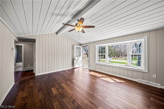 spare room featuring dark hardwood / wood-style flooring, ceiling fan, and vaulted ceiling with beams